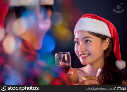 Asian woman looking at her boyfriend in Christmas and New year party. Night life and First love concept. First impression and Happiness concept. Couples and Lovers theme. Color blurry Bokeh foreground