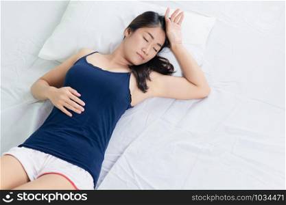 Asian woman lying and sleep on the bed top view