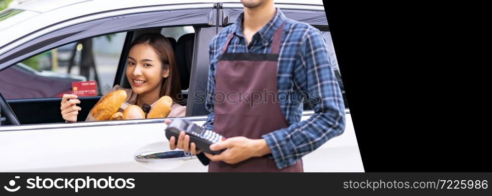 Asian woman make mobile payment contactless technology for online grocery ordering and drive thru service. Drive through is popular after pandemic. Panorama web banner with free copyspace for editing.