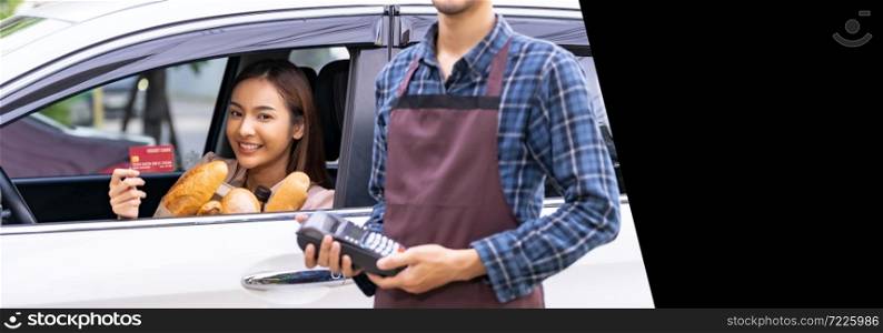 Asian woman make mobile payment contactless technology for online grocery ordering and drive thru service. Drive through is popular after pandemic. Panorama web banner with free copyspace for editing.