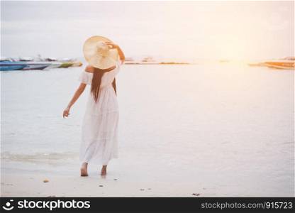 Asian woman on beach enjoying travel and fresh air in holidays. Vacation and Outdoors concept. People and Nature concept. Asian beauty and Sea theme.