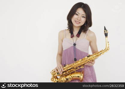 Asian woman playing saxophone