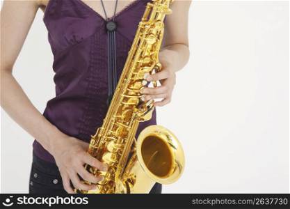 Asian woman playing saxophone