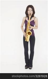 Asian woman playing saxophone