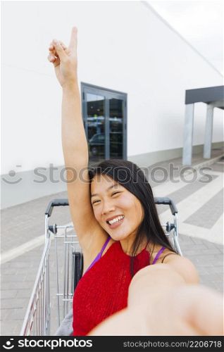 asian woman posing taking selfie shopping trolley