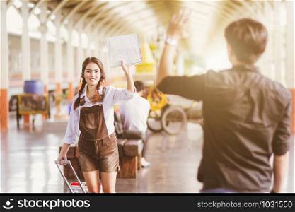 Asian woman pregnant Hold map say goodbye With a young man in at in a train station