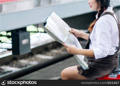 Asian woman pregnant look at the map at railway station travel.