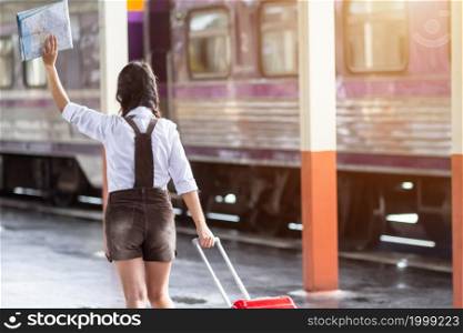 Asian woman pregnant travel carrying her trolley red bag and map at railway station travel,traveler with backpack in summer Holiday concept Thailand