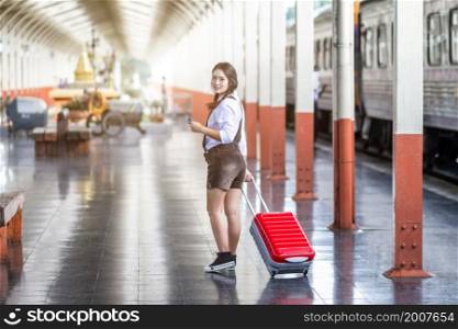 Asian woman pregnant travel holding the Smartphone at railway station travel,traveler with backpack in summer Holiday concept Thailand