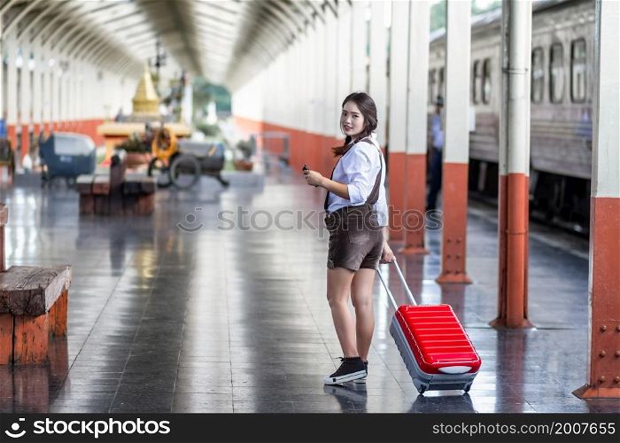 Asian woman pregnant travel holding the Smartphone at railway station travel,traveler with backpack in summer Holiday concept Thailand