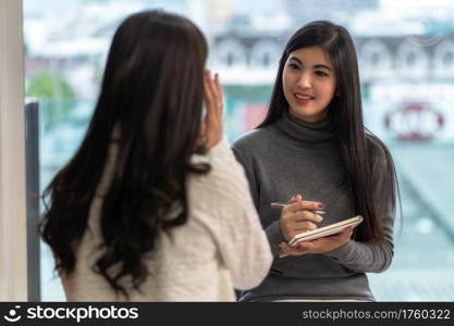 Asian woman professional psychologist doctor giving the consult to female patients in modern living room of house or hospital exam room, Mental health Concept