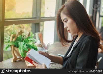 Asian woman reading a book for relaxation .