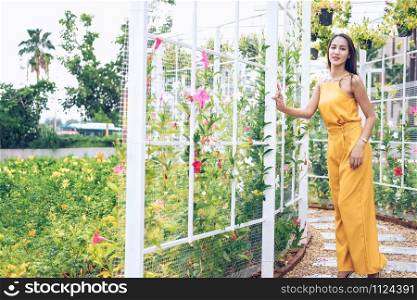 asian woman relaxing enjoying summer nature in flower garden