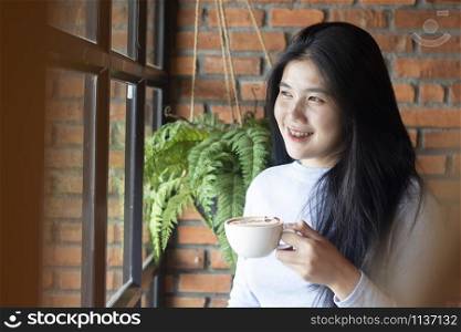 Asian woman relaxing with coffee at home in the living room