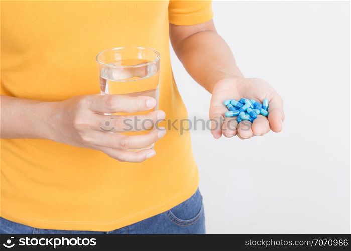 Asian woman&rsquo;s hand holding capsule and glass on white background,Health and medical concept