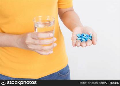 Asian woman&rsquo;s hand holding capsule and glass on white background,Health and medical concept