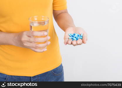 Asian woman&rsquo;s hand holding capsule and glass on white background,Health and medical concept