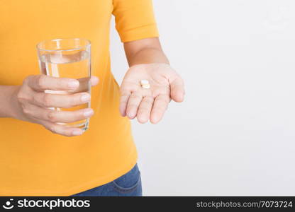 Asian woman&rsquo;s hand holding painkillers and glass on white background,Health and medical concept