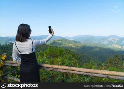 Asian woman selfie travel in holiday. Background mountain and forest in winter season.