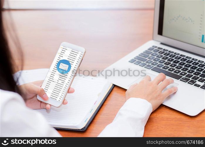 Asian woman sending email contact. gesture of finger pressing send on mobile smart phone and laptop computer, technology communication concept.