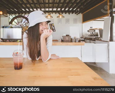 Asian woman show plastic credit card in cafe.