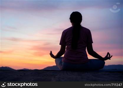 asian woman sit lotus yoga position at sunset . Practicing yoga makes meditation for healthy breathing and relaxation
