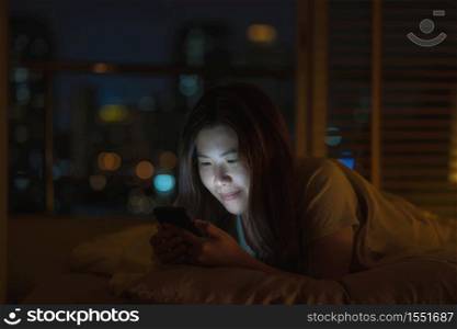Asian woman sleeping and using smart mobile phone for social network or video conference call when Covid19 Outbreak, quarantine, and Coronavirus pandemic, Social distancing and new normal concept