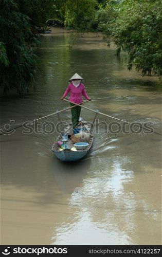 Asian woman steering boat
