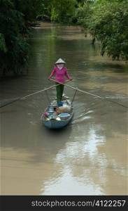 Asian woman steering boat