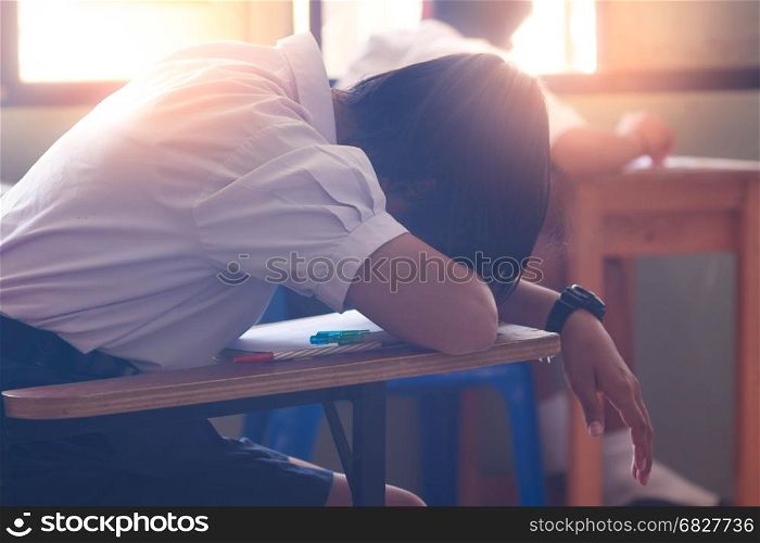 Asian woman student sleep on the table in classroom.