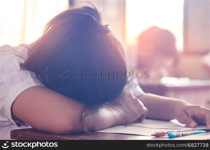 Asian woman student sleep on the table in classroom.