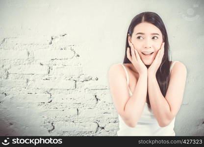 Asian woman surprise hold cheek with hand, Beautiful girl with presenting your product with expression excited and surprise on cement background, Expressive facial emotion concept.