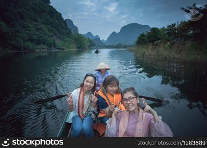 asian woman toothy smiling face happiness emotion sailing boat in ninh binh canal most popular traveling destination in vietnam