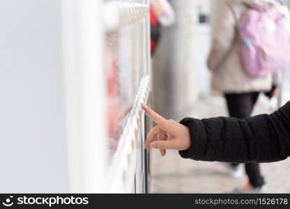 Asian woman traveler choosing product from vending machine in winter Japan.