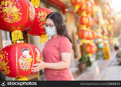 asian woman traveler wear protective mask germs and red with paper lanterns with the Chinese text Blessings written on it Is a Fortune blessing compliment decoration at Chinese shrine,Chinese New Year