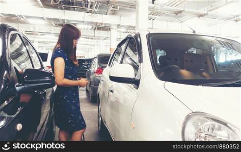 asian woman use key to open or lock her car