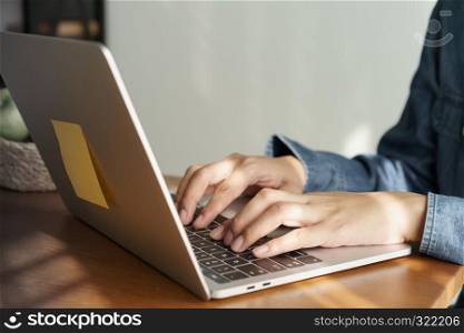 Asian woman using a laptop computer, business women are working with notes book in office