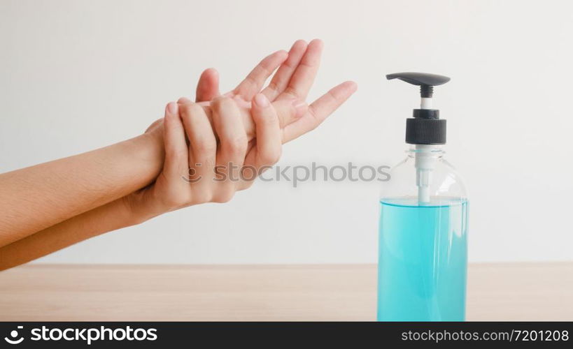 Asian woman using alcohol gel hand sanitizer wash hand for protect coronavirus. Female push alcohol bottle to clean hand for hygiene when social distancing stay at home and self quarantine time.