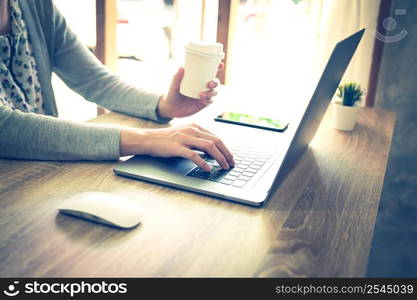 asian woman using laptop computer do online activity on wood table at home office.