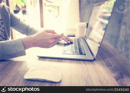 asian woman using laptop computer do online activity pay credit card on wood table at home office.