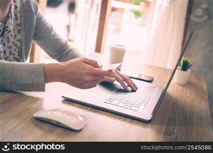 asian woman using laptop computer do online activity pay credit card on wood table.