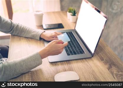 asian woman using laptop computer do online activity pay credit card on wood table.