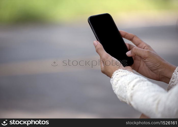 Asian woman using smartphone reading online social media shopping online website on smartphone with smile face. Happiness asian woman holding cellphone checking mail read Blog vlog social media