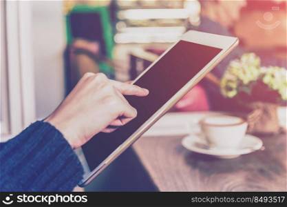 Asian woman using tablet computer in coffee shop with Vintage tone.