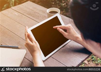 Asian woman using tablet in garden at coffee shop with vintage tone.
