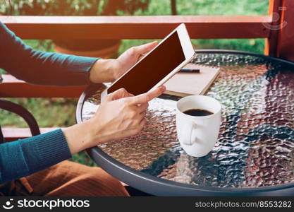 asian woman using tablet on table and coffee in garden with vintage toned.