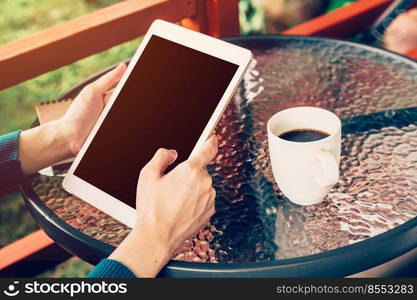 asian woman using tablet on table and coffee in garden with vintage toned.