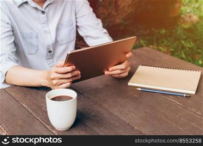Asian woman using tablet on table in coffee shop with vintage toned.