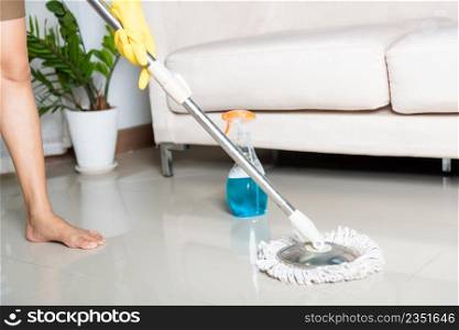 Asian woman washes the floor with a mop and rag indoors, housewife washing floor mopping at home in living room cleaning her home, Professional housekeeping job house cleanup concept
