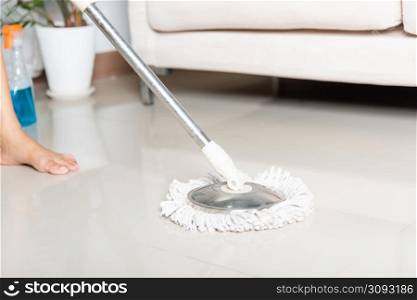Asian woman washes the floor with a mop and rag indoors, housewife washing floor mopping at home in living room cleaning her home, Professional housekeeping job house cleanup concept